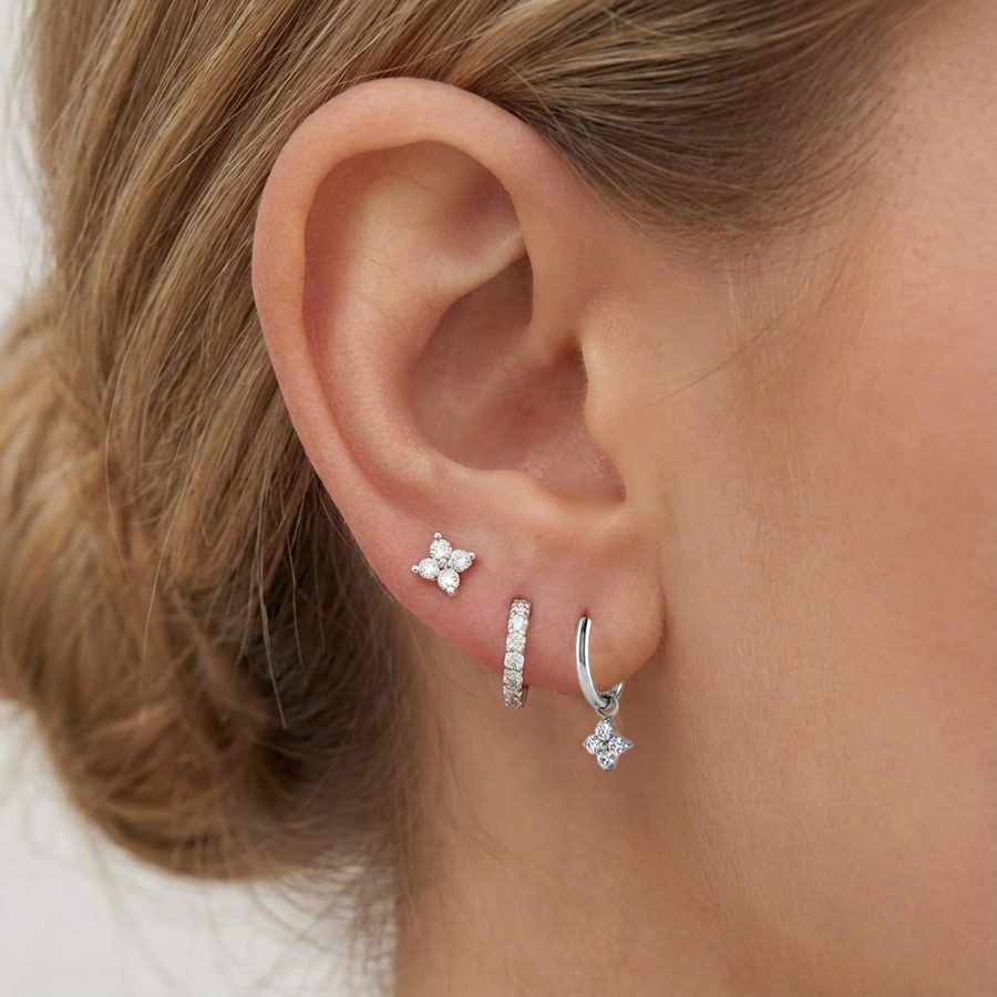 Ear styled with a flower stud, a crystal huggie and a flower charm hoop